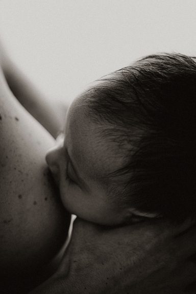Bebé mamando del pecho de su madre en un momento íntimo.