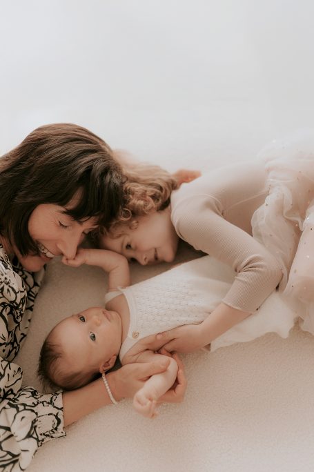 Madre abrazando a su bebé en un entorno suave y acogedor. Ambos lucen felices.