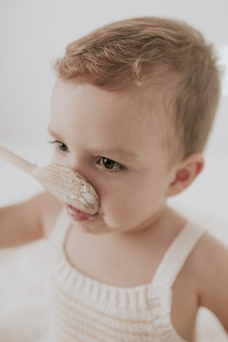 Un niño pequeño con una cuchara de madera, comiendo con entusiasmo.